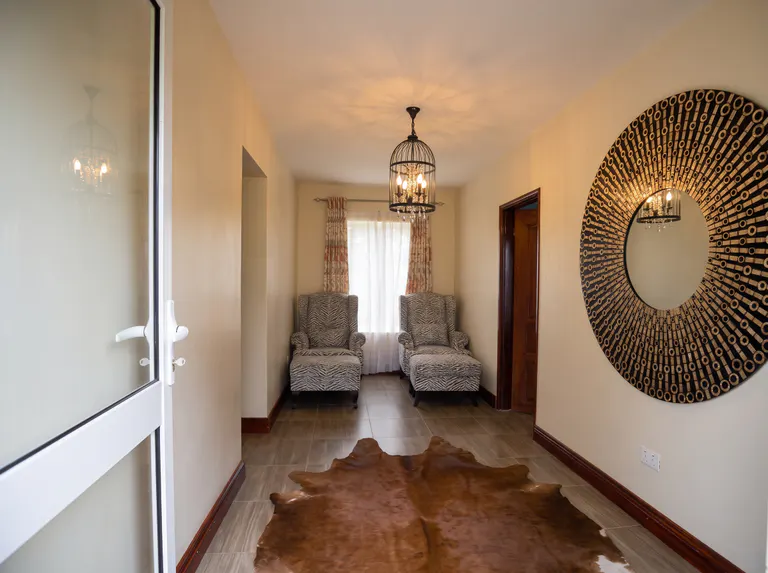 A refined sitting area at The Nyakaju with comfortable chairs and cultural decor.
