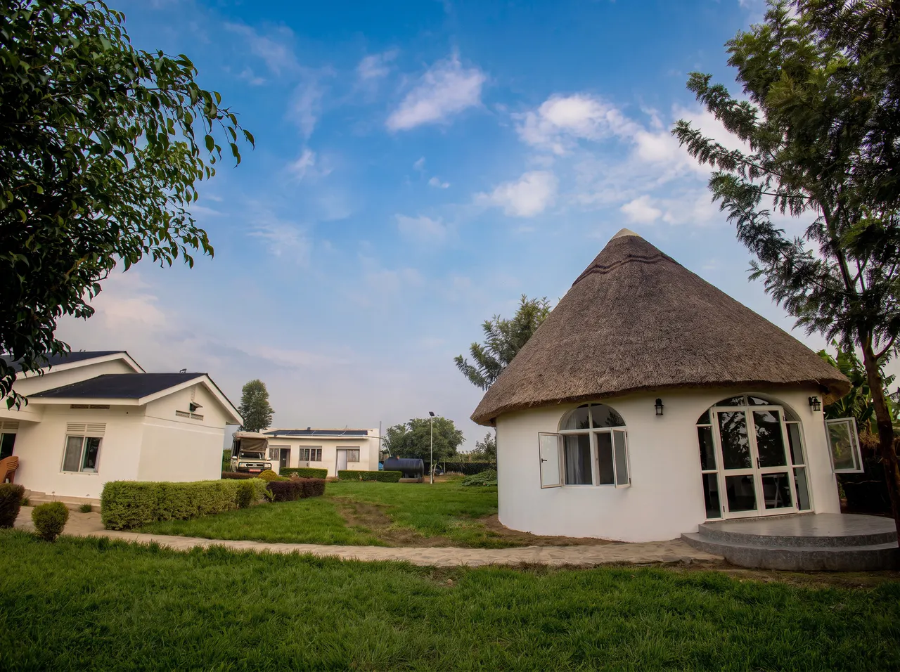 The Nyakaju compound with a traditional round thatched building and guest accommodation.