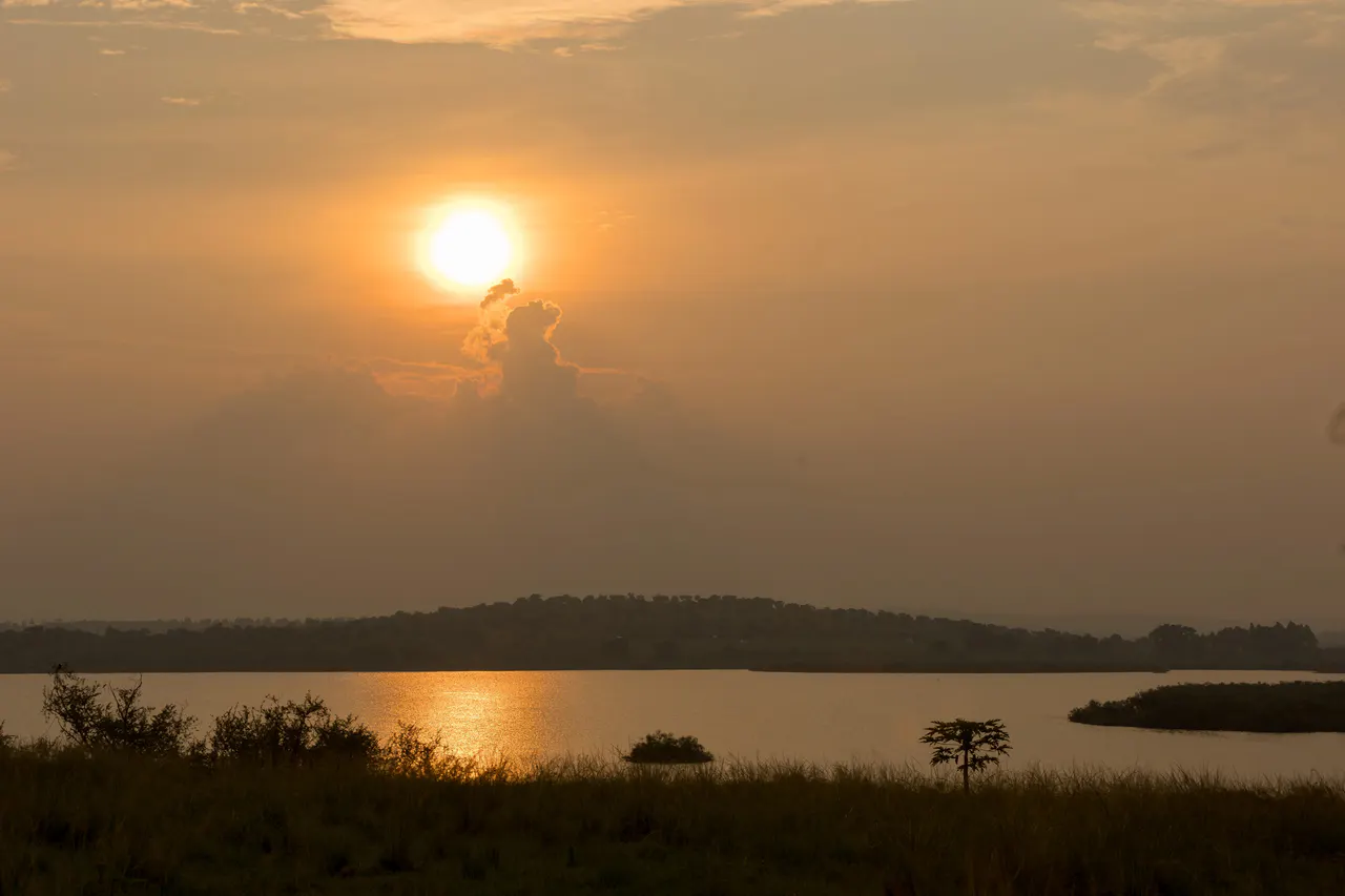 A golden sunset over the water and rolling landscape near The Nyakaju.