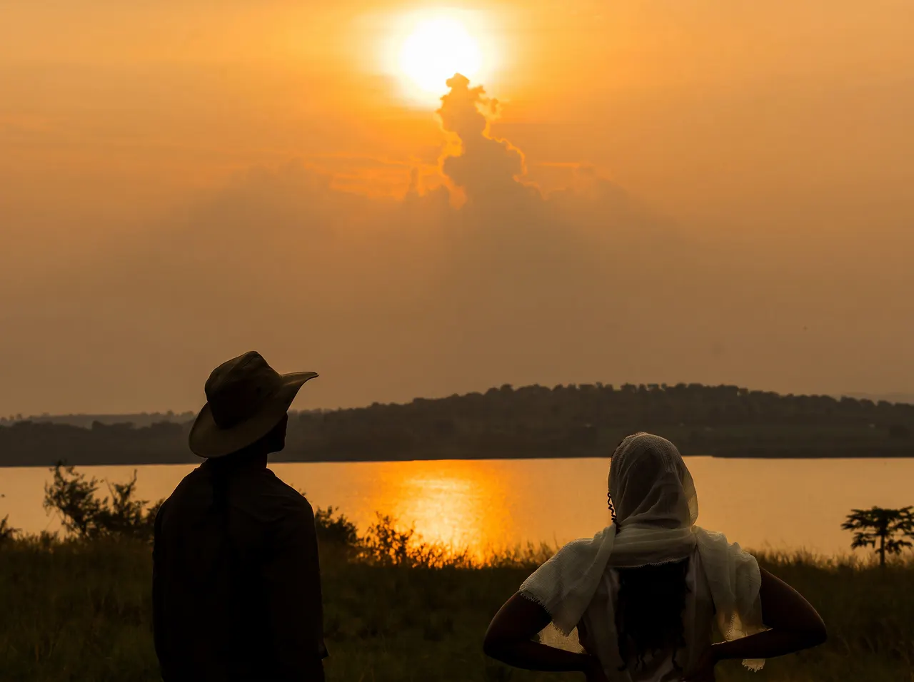 Two guests watching the sunset over the water near The Nyakaju.